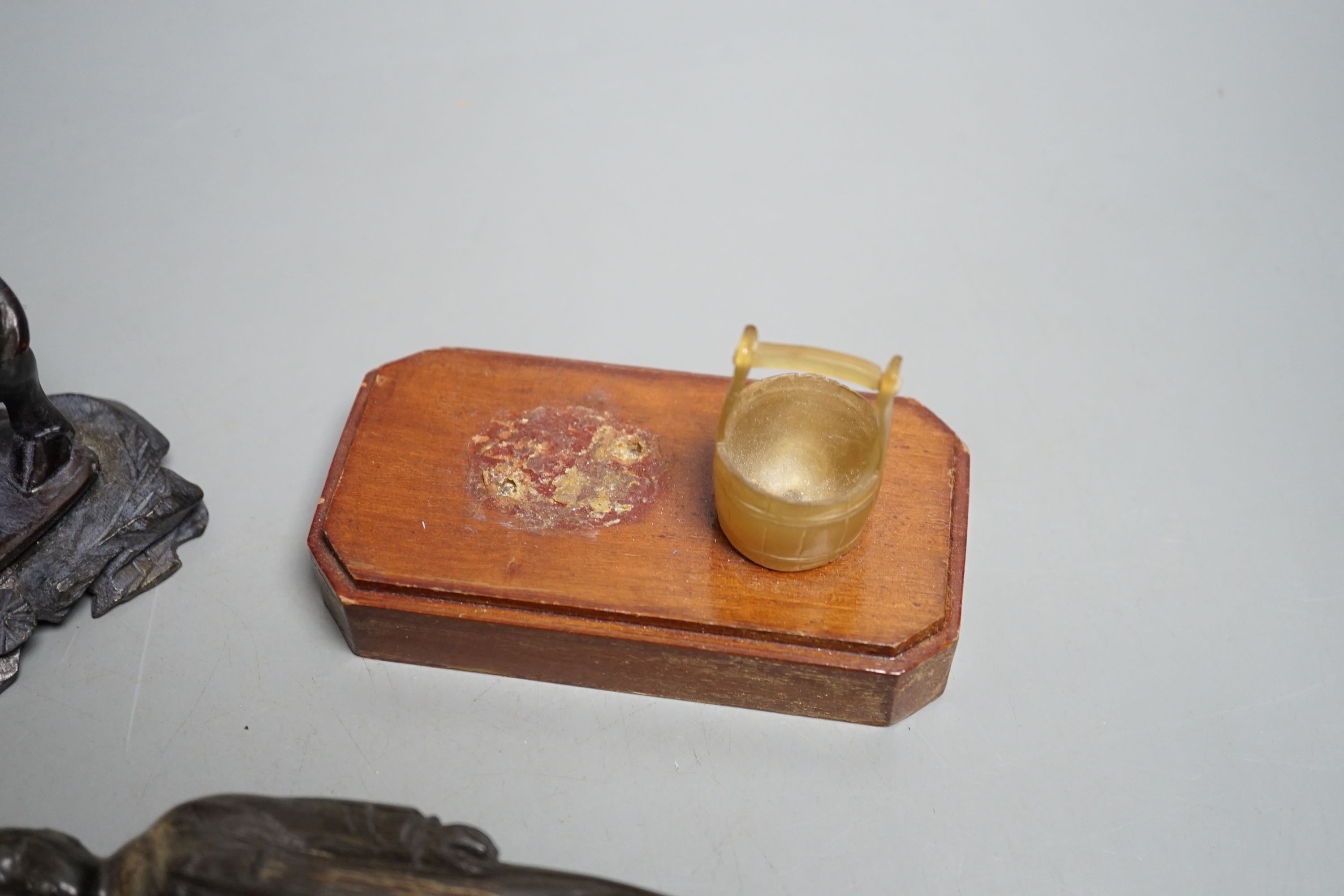 A Chinese horn figure and a carved hardwood figure riding a buffalo,13 cms wide.